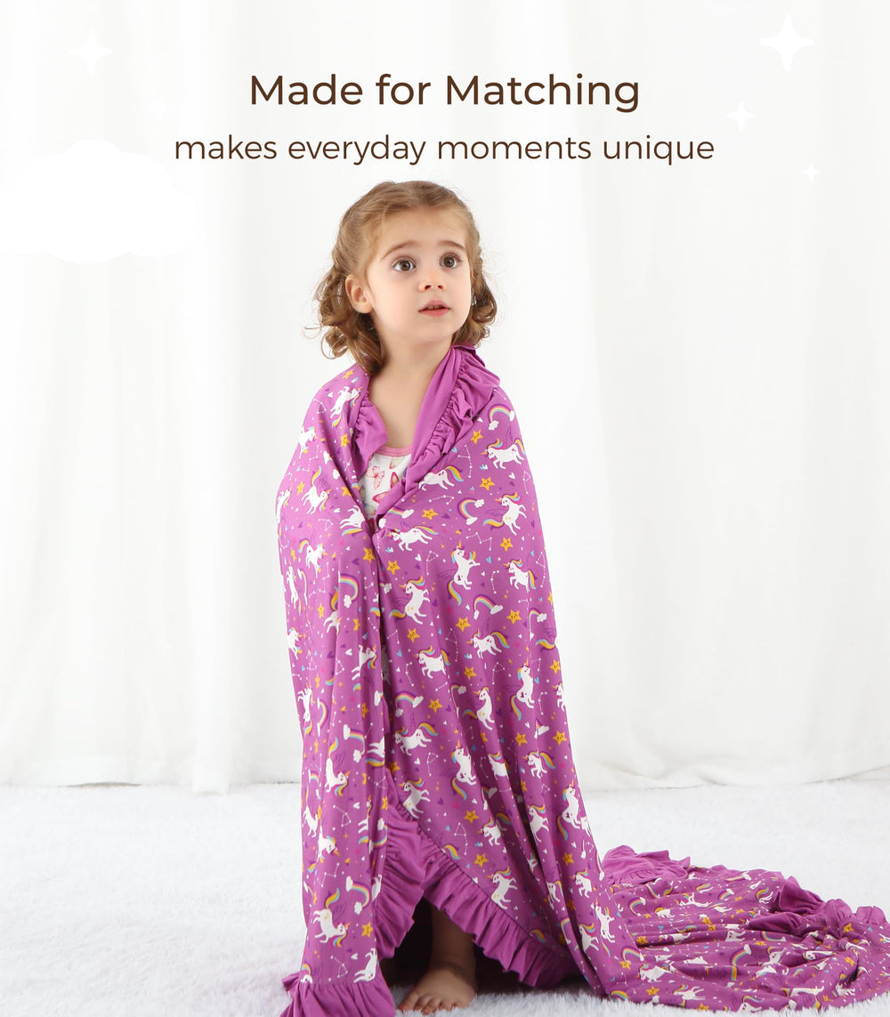 DREAMHALO purple unicorn nursery blanket on a crib adds playful charm and cozy warmth.