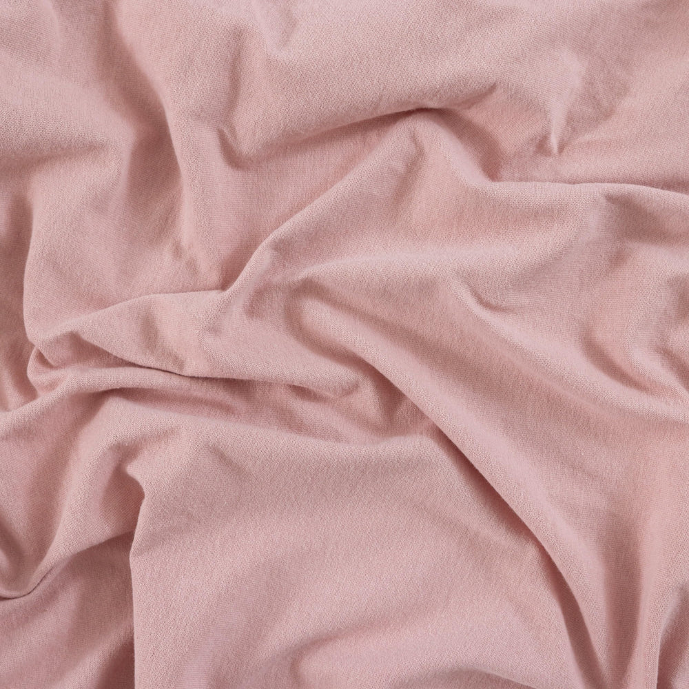 Dreamology Jersey Crib Sheets in dusty pink tones suitable for both boy and girl nurseries.