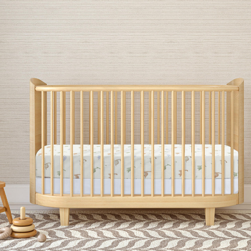 Dreamology nursery setup shows Dino-design crib sheet for a calm space.
