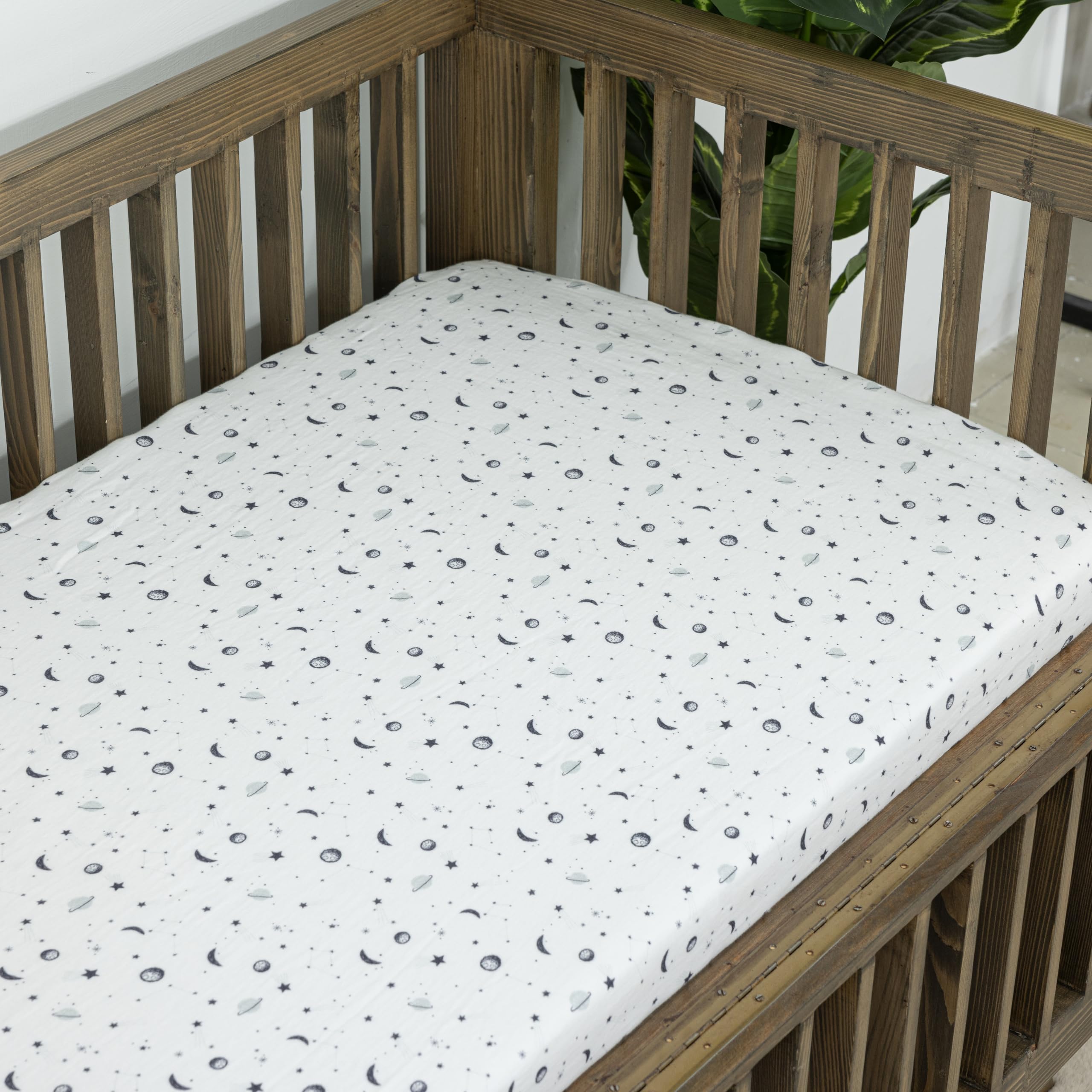 Dreamology Planets crib sheets used on toddler bed illustrating wrinkle-free bedding transition.