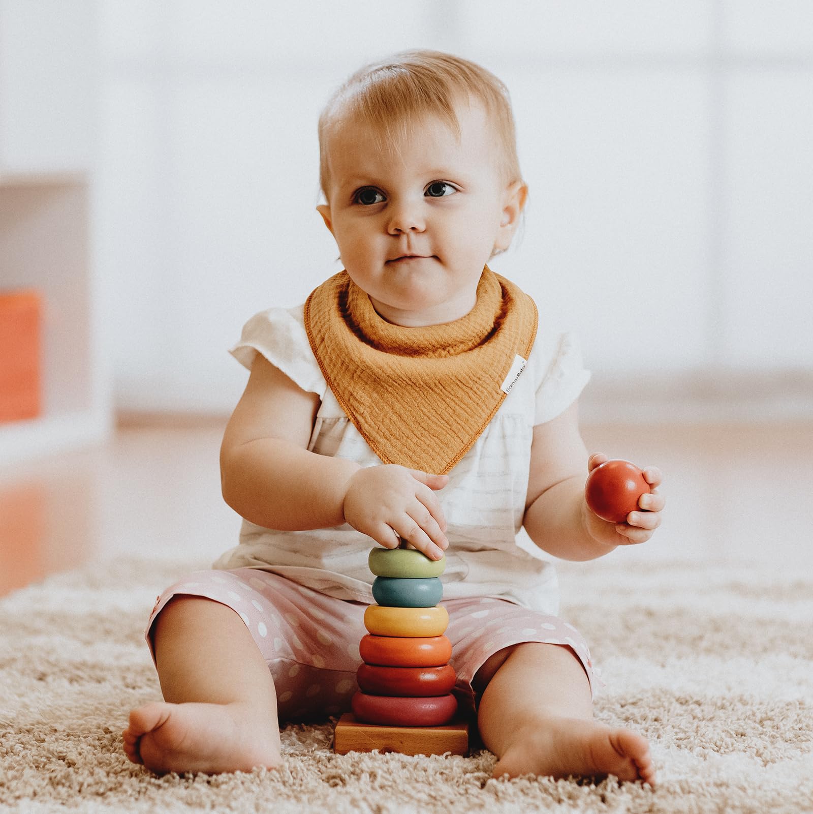 Egmao Baby muslin bibs worn flat and staying in place during feeding and play.