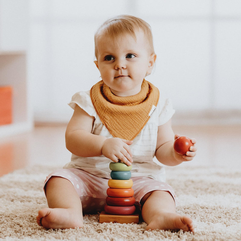 Egmao Baby muslin bibs worn flat and staying in place during feeding and play.