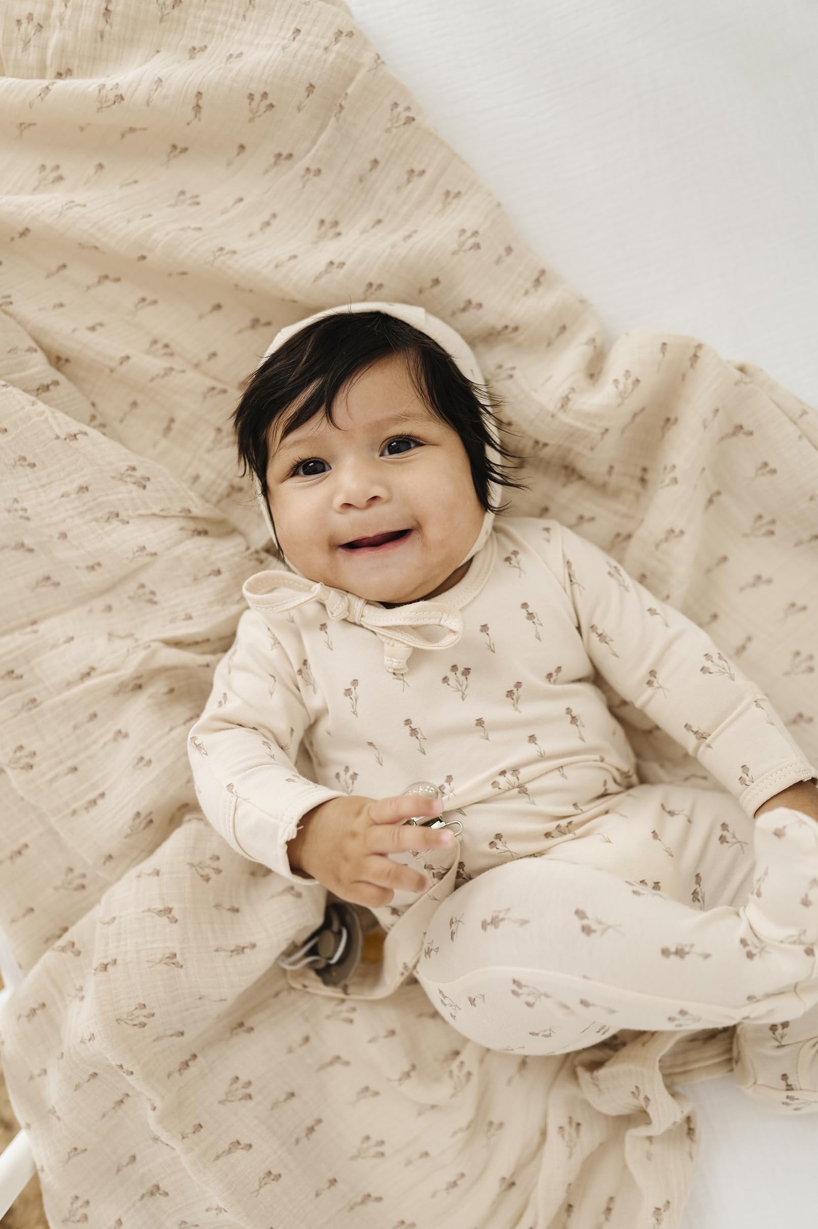 Ely's & Co. muslin swaddle wrapped baby demonstrates secure, cozy swaddle