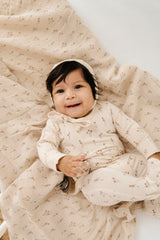 Ely's & Co. muslin swaddle wrapped baby demonstrates secure, cozy swaddle
