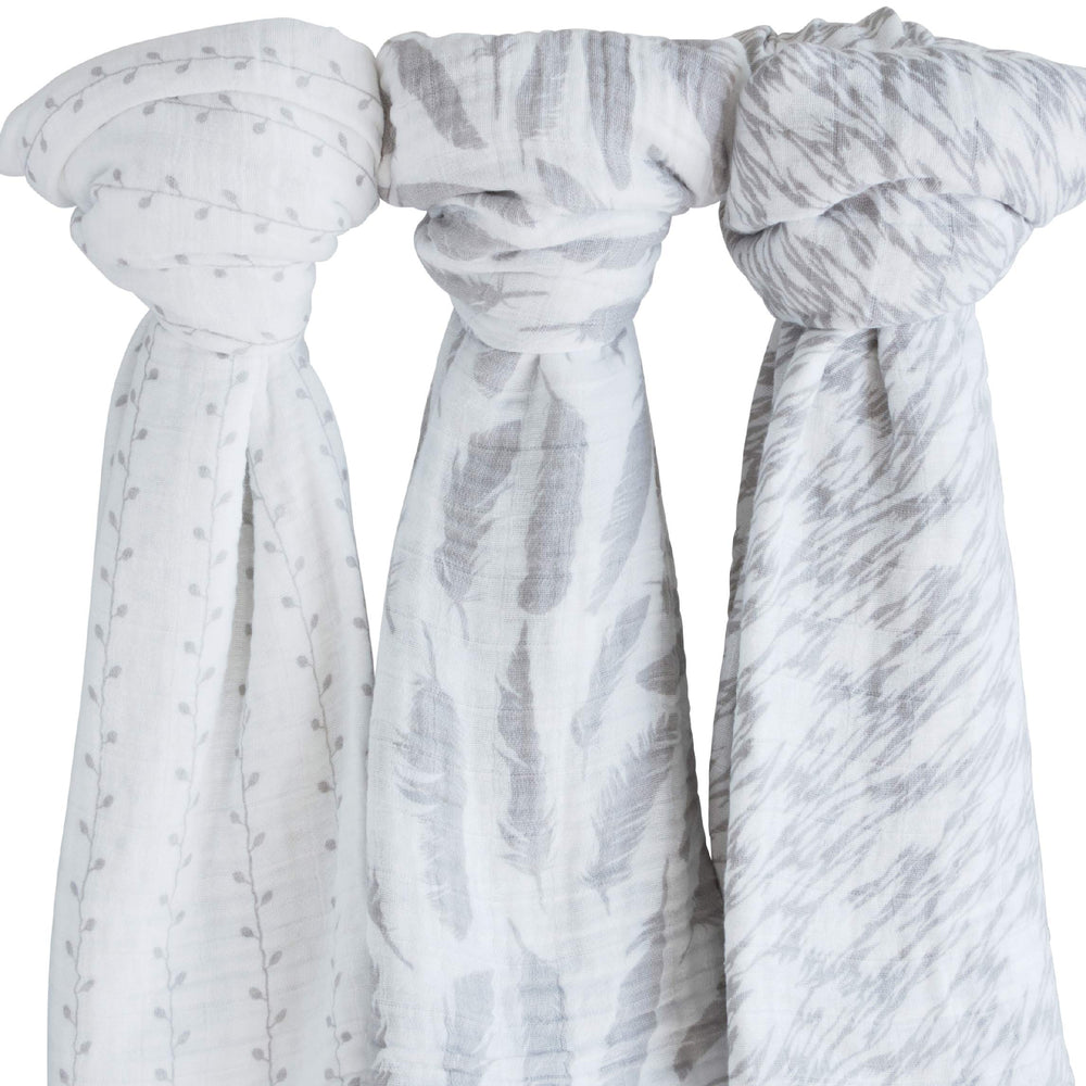 Ely's & Co muslin swaddle demonstrates newborn swaddling in a cozy nursery.
