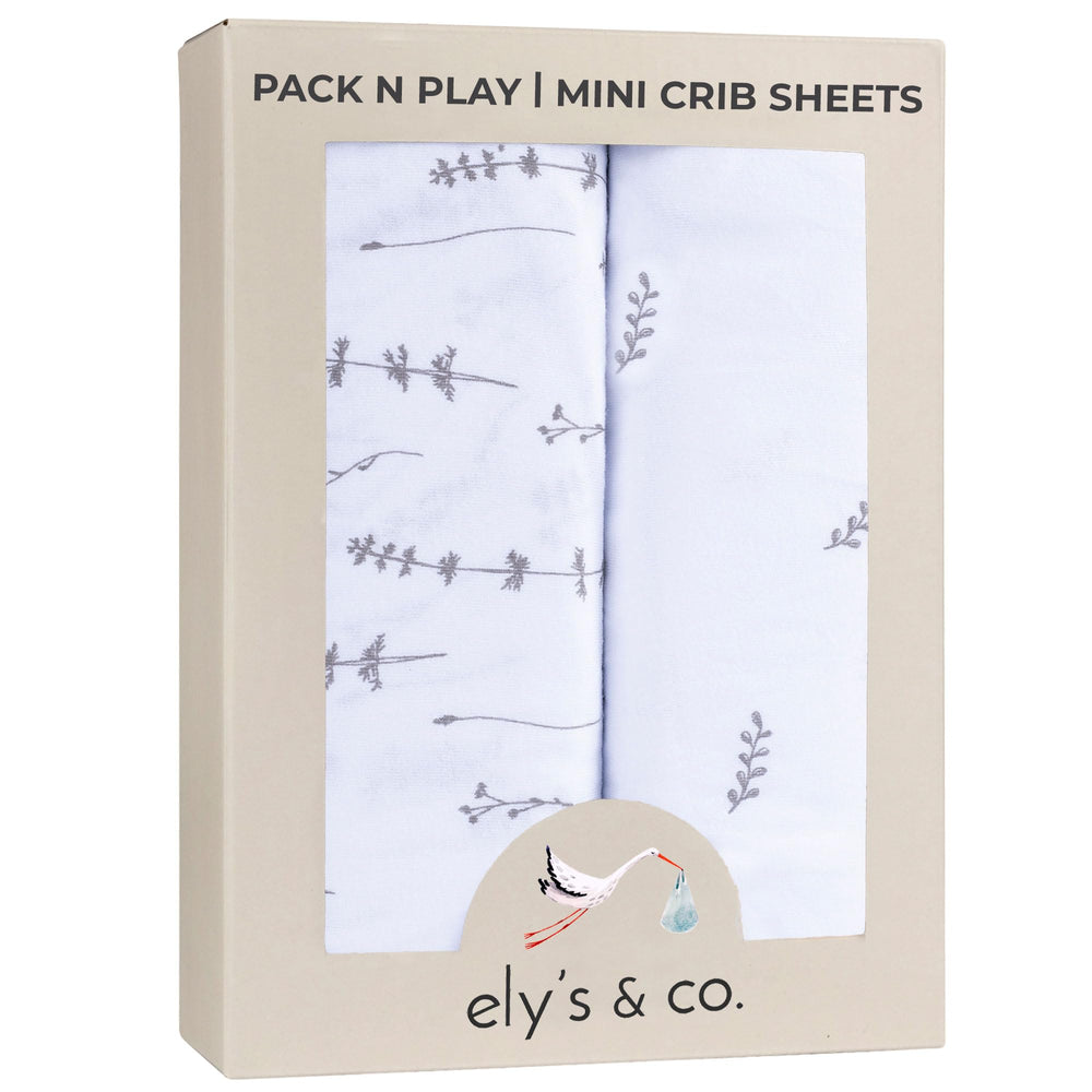 Ely's Co Pack N Play sheets folded with forest grey floral pattern for cozy naps