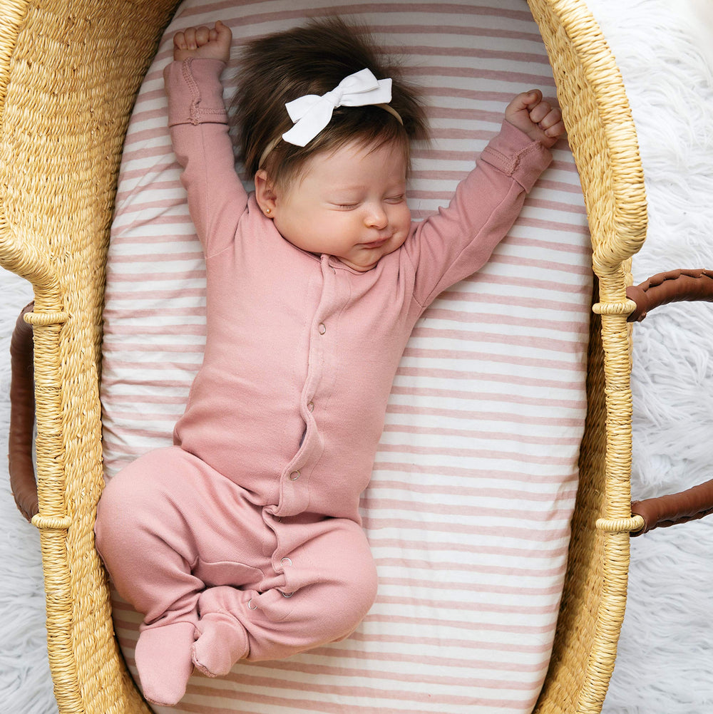 Pattern close-up shows mauve stripes and splash designs for nursery styling