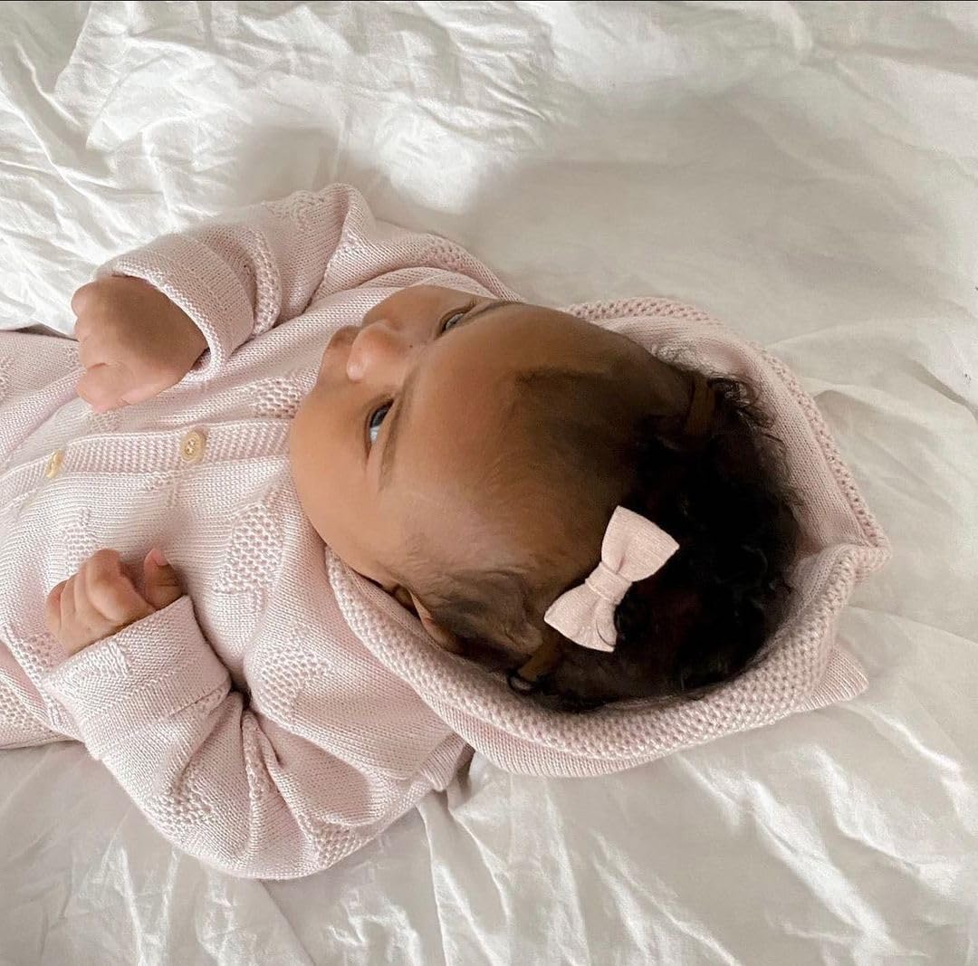 Fancy Clouds 2-inch baby bows held in hand show ideal sizing for babies
