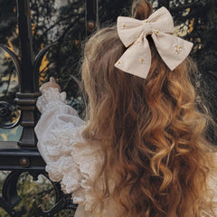 Fancy Clouds storage-strip bow display on wooden ring with lace trim.