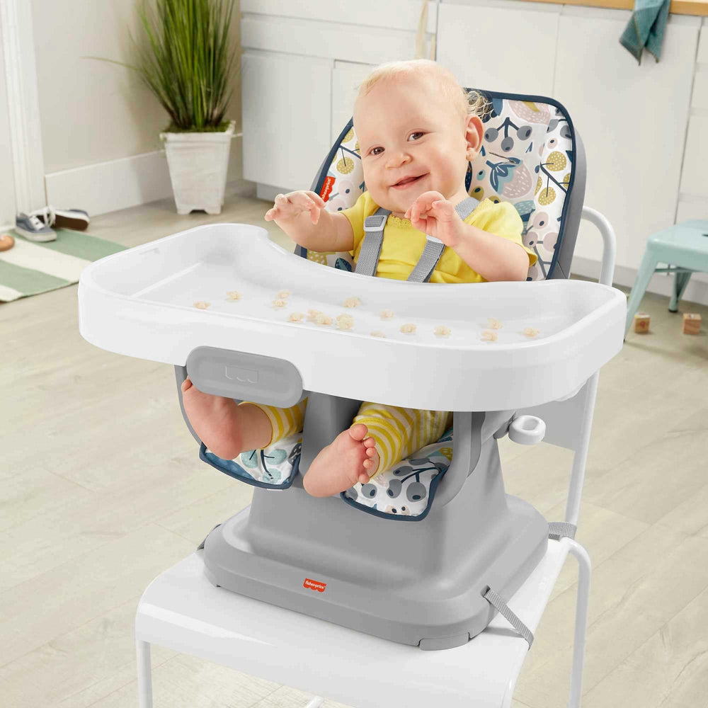 Fisher-Price SpaceSaver high chair navy foliage in-use—adjustable recline for comfortable feeding.
