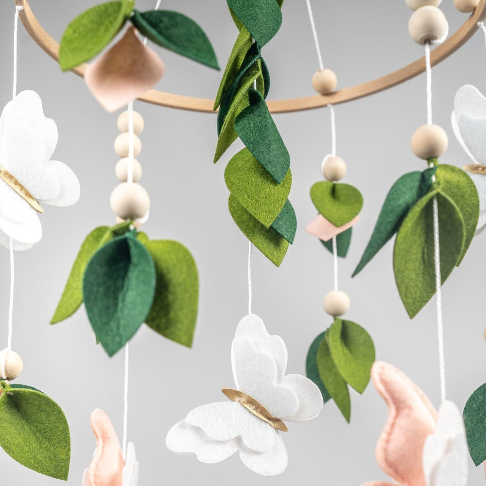 Flora & Ivy butterfly mobile pink-white-gold close-up shows handcrafted felt details and soft textures.