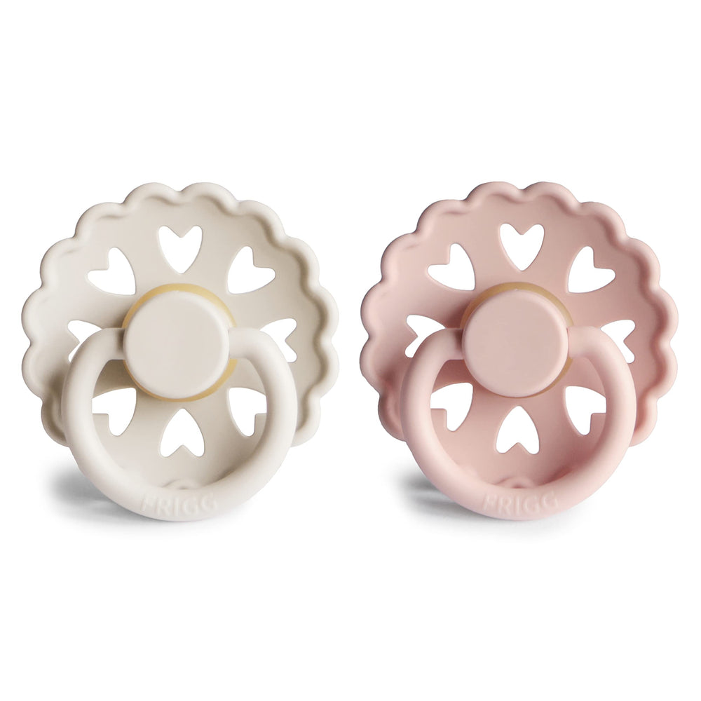 FRIGG Andersen Fairytale pacifier cream-blush held by mom for easy soothing during feeds.