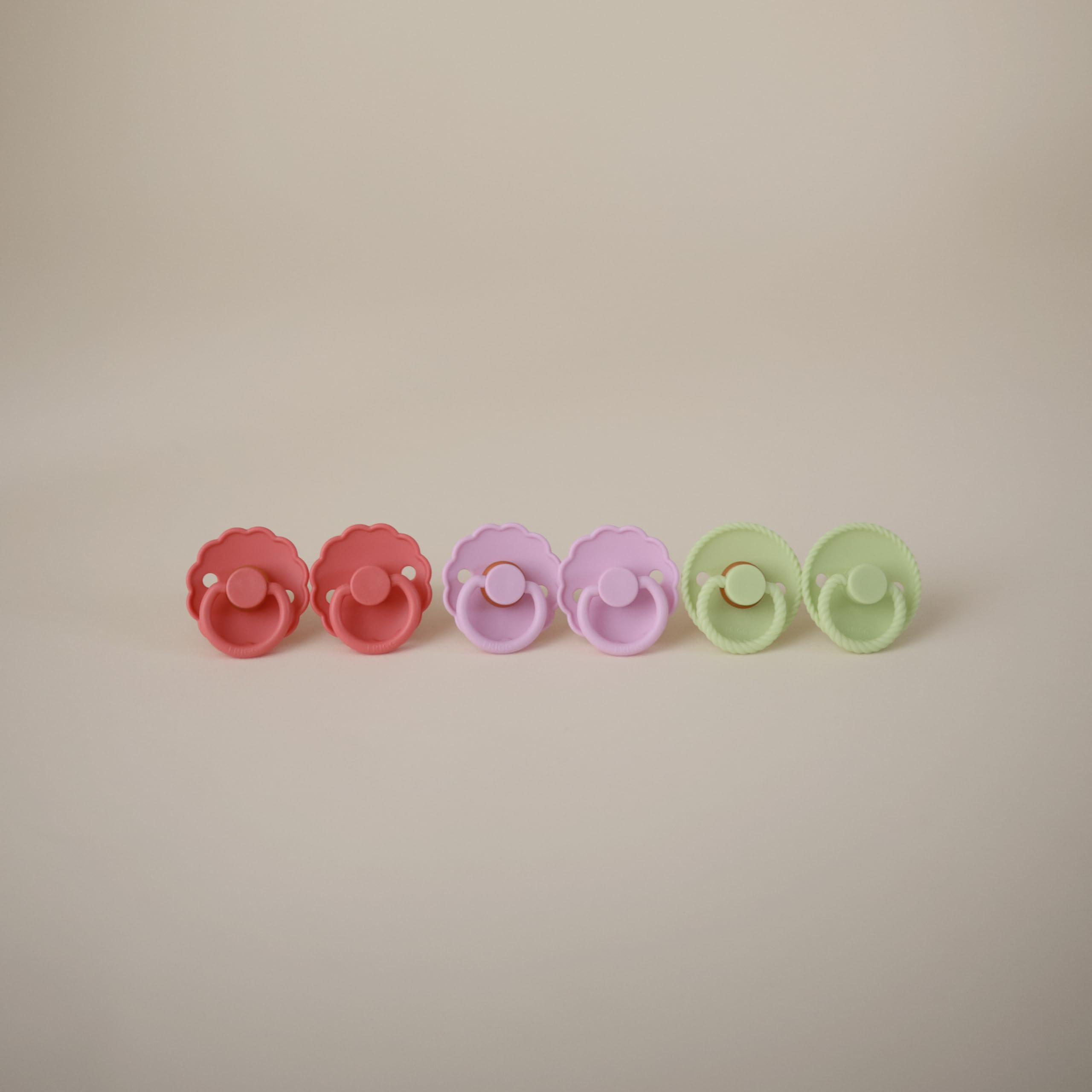 Frigg Daisy silicone pacifier Click-lock system for secure attachment.