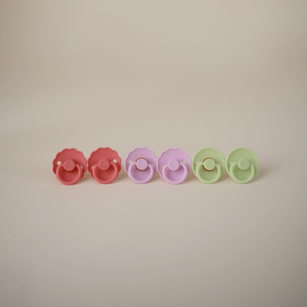 Frigg Daisy silicone pacifier Click-lock system for secure attachment.