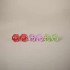 Frigg Daisy silicone pacifier Click-lock system for secure attachment.