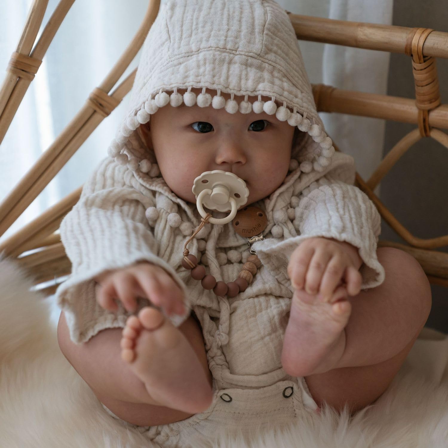 FRIGG pacifier air holes and security handle enhance safety features.