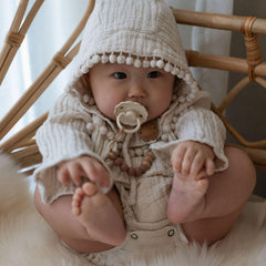 FRIGG pacifier air holes and security handle enhance safety features.