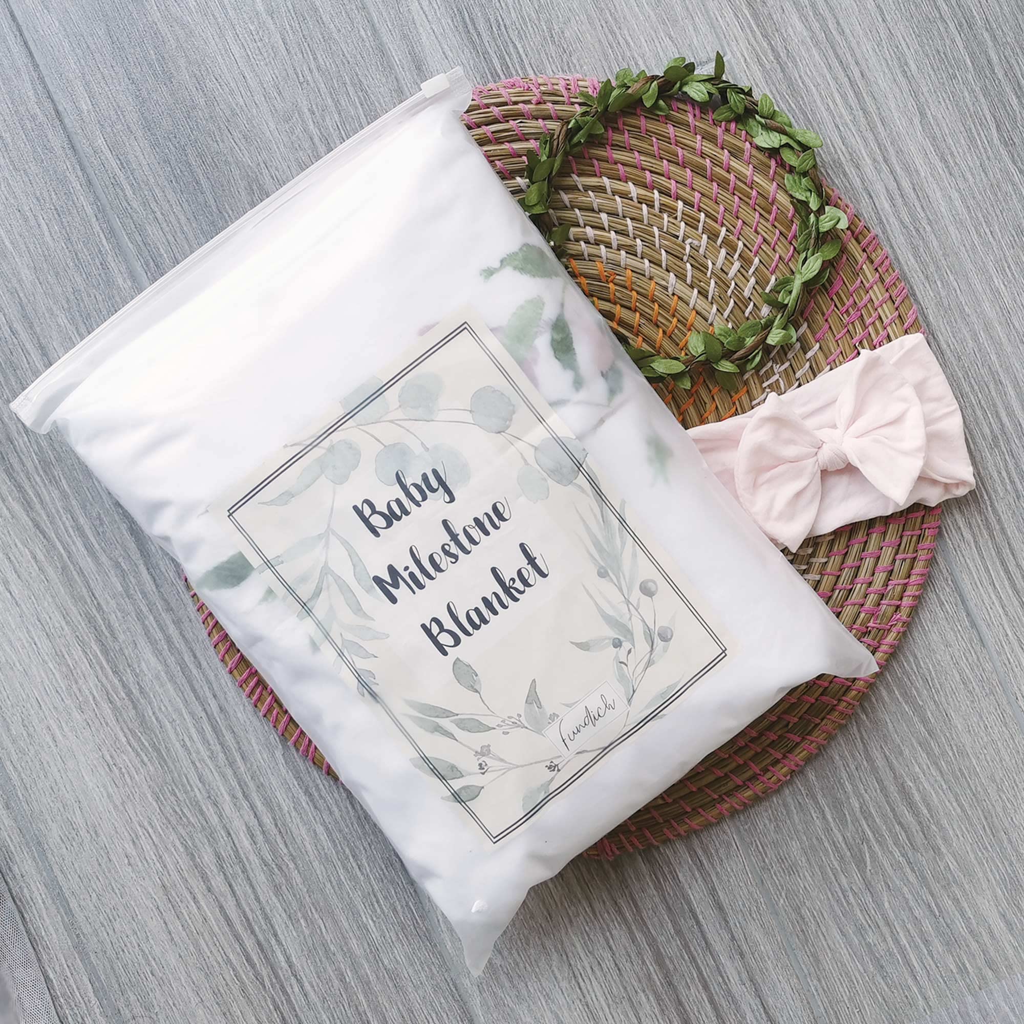Fundich milestone blanket with wreath marker, helps showcase monthly growth in photos.