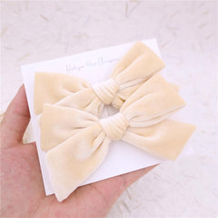 Gebelle cream velvet bow on child — festive holiday styling.