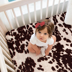 Glenna Jean Black Cow crib sheet on mattress—cozy sleep-ready surface.