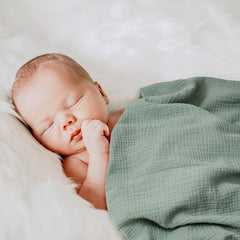 GLLQUEN BABY muslin receiving blanket in use as snug wrap