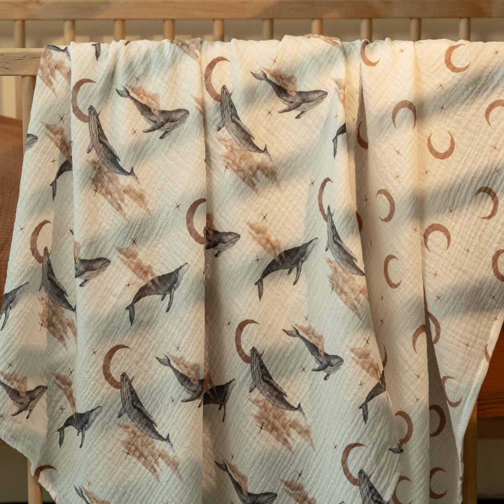 GLLQUEN BABY swaddle blanket in use to wrap a sleeping baby for calm soothing.