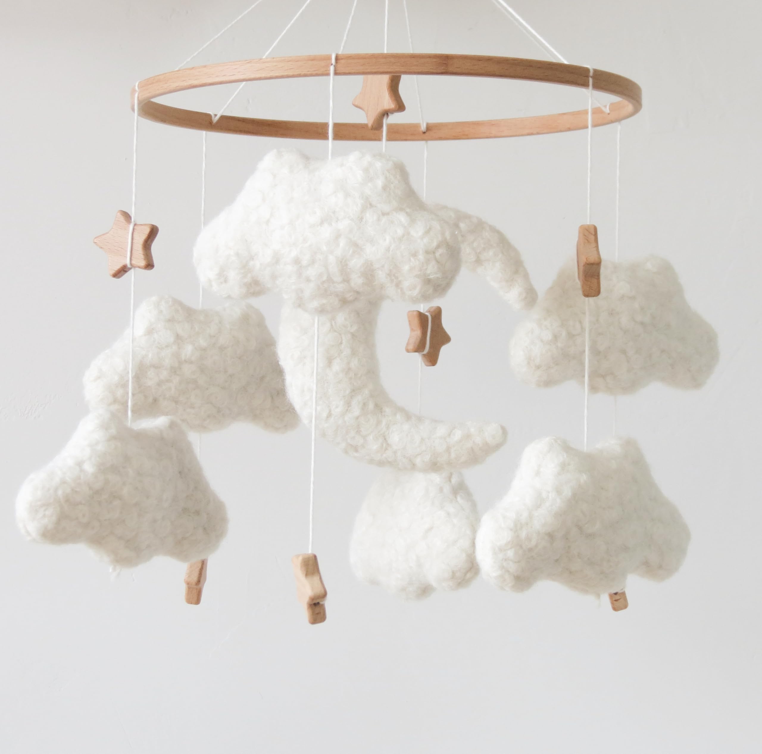 GOUKURLSMA cloud mobile in neutral cream tones harmonizes with boho nurseries and softens lighting.