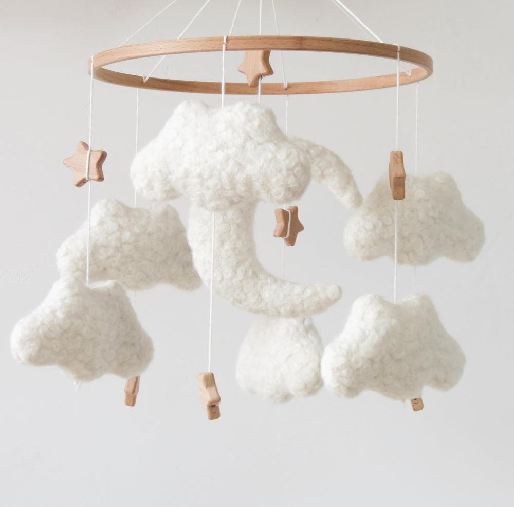 GOUKURLSMA cloud mobile in neutral cream tones harmonizes with boho nurseries and softens lighting.