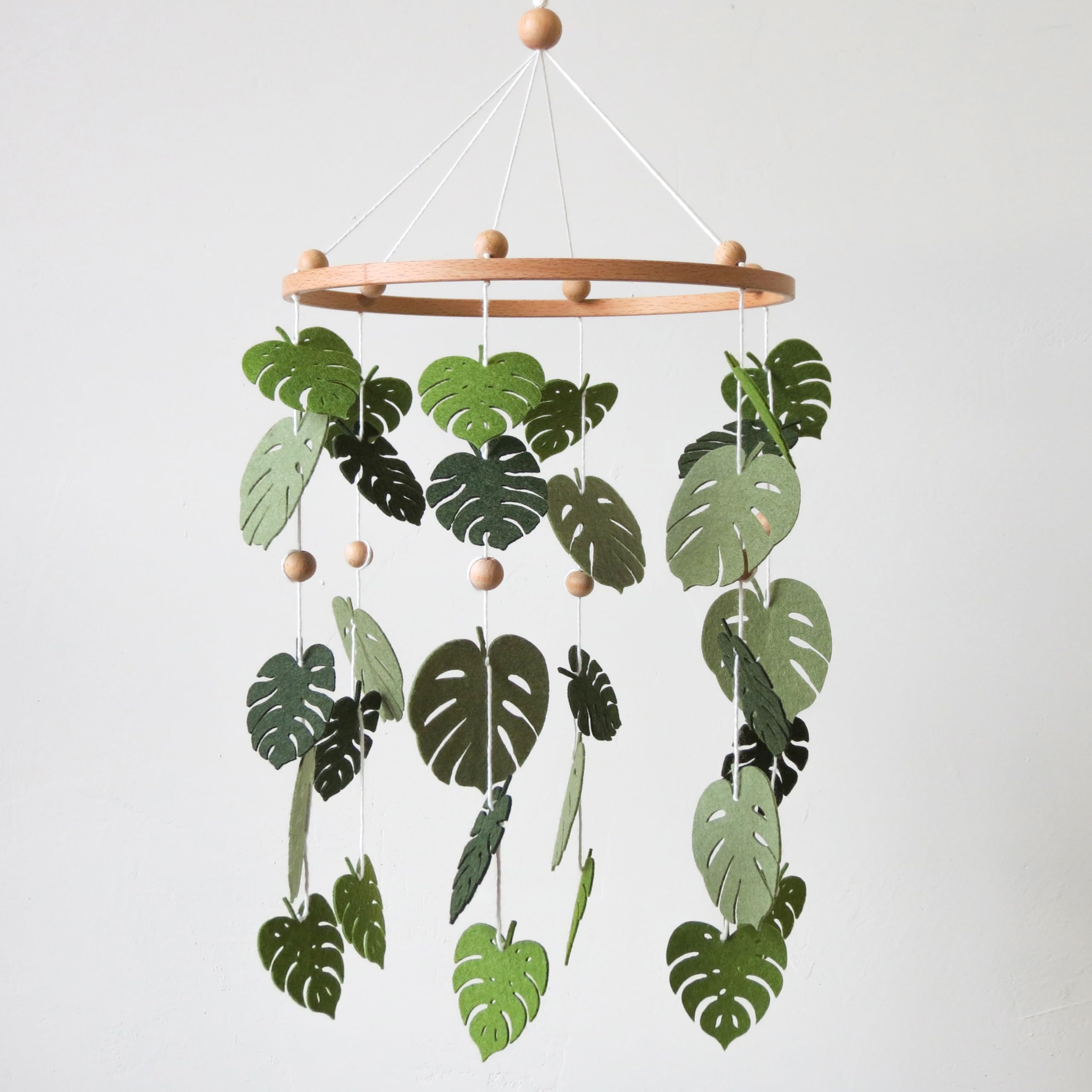 Goukurlsma green leaf mobile forest crib setup promotes visual tracking for babies.