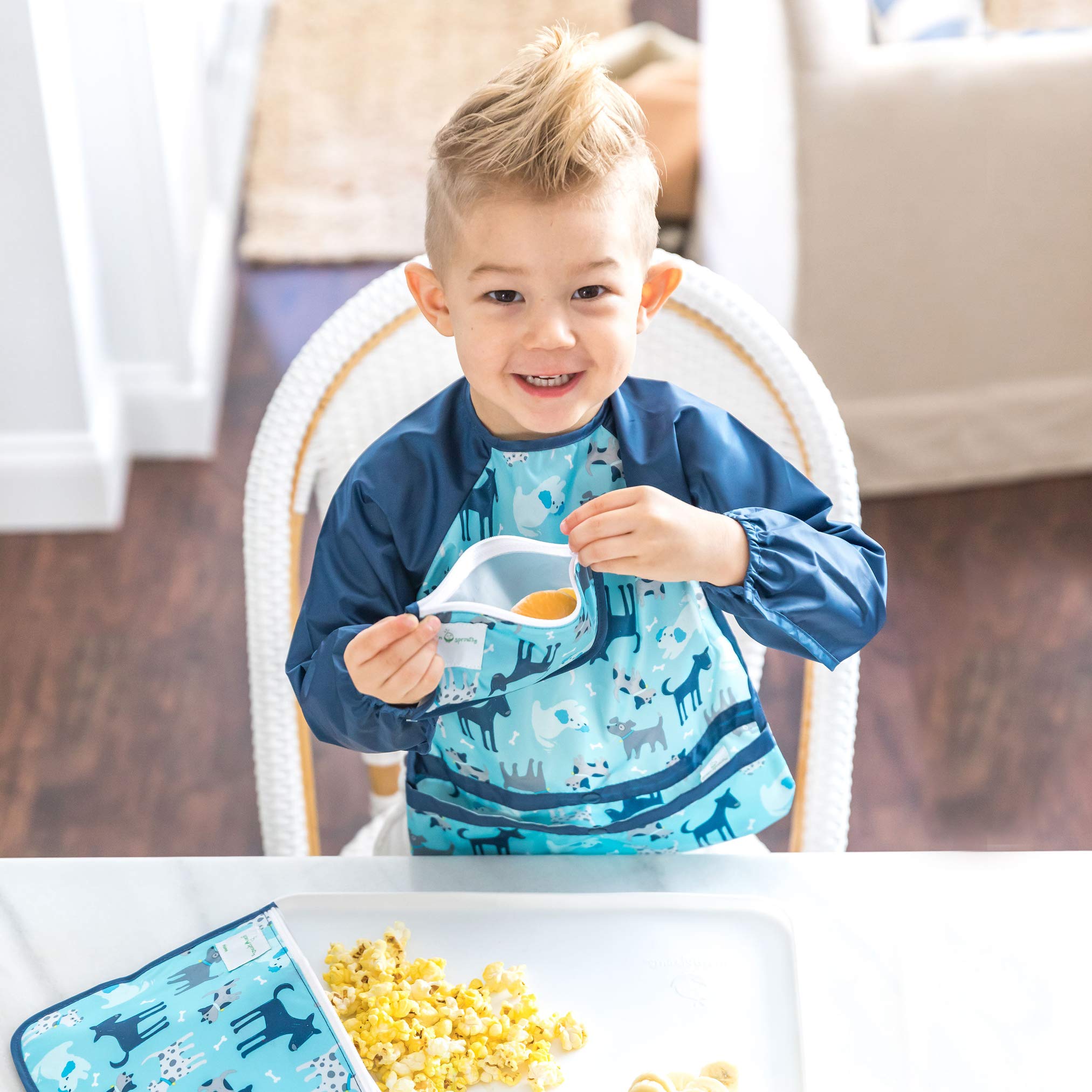 Green Sprouts Easy-Wear Long Sleeve Bib demonstrates waterproof protection to keep outfits clean.