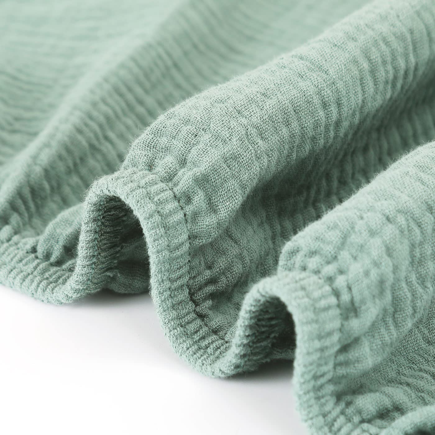 GRSSDER Roman Green crib sheet on a baby sleeping scene in a calm nursery