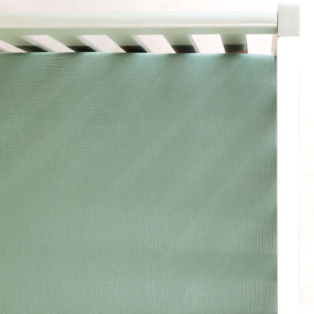 GRSSDER soft muslin crib sheet in Roman Green viewed full on bed for soft, breathable comfort