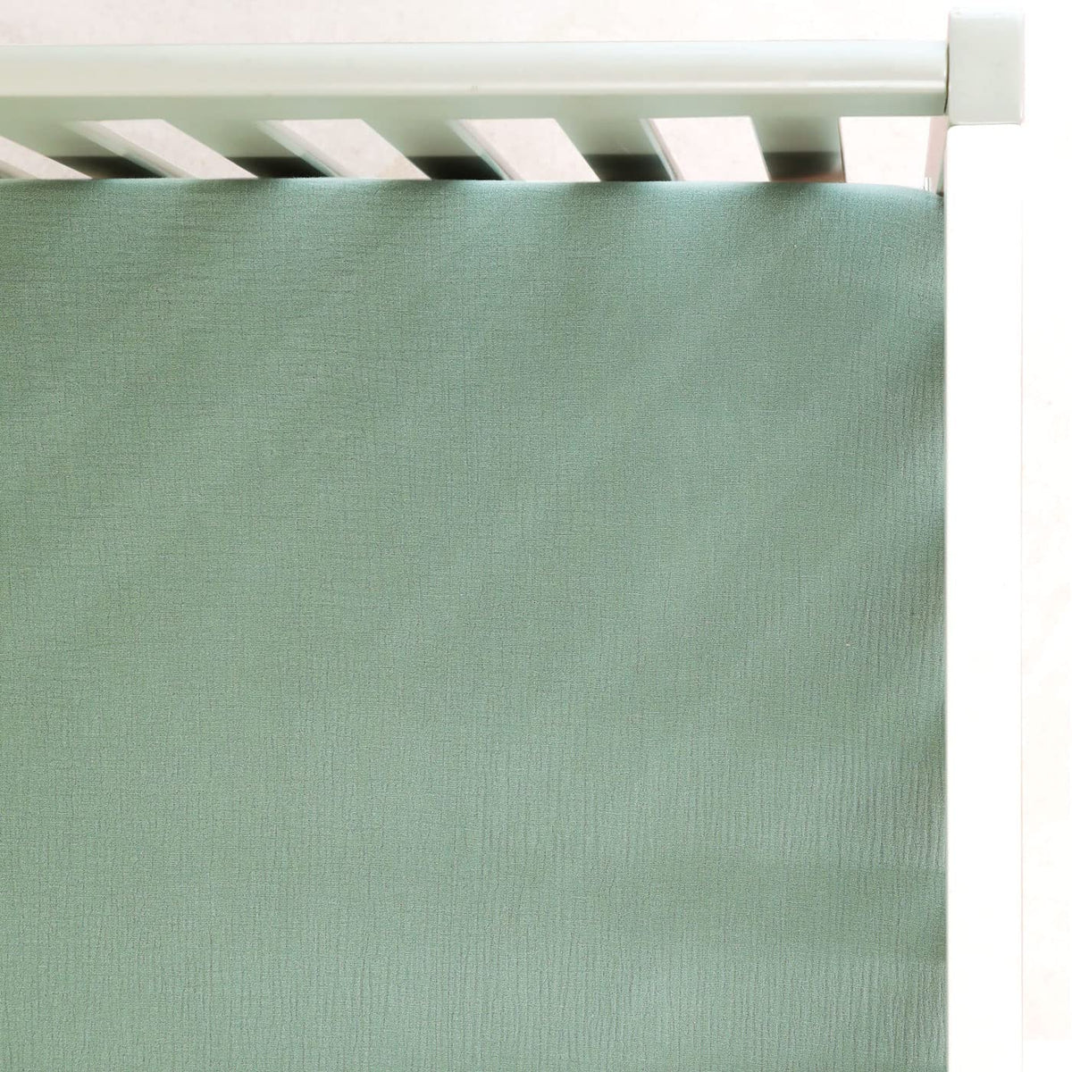 GRSSDER soft muslin crib sheet in Roman Green viewed full on bed for soft, breathable comfort