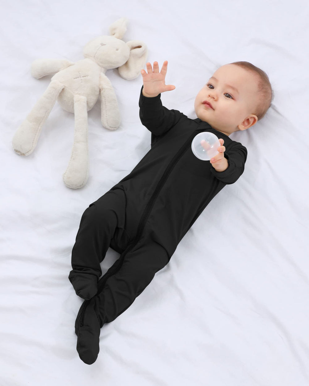 GUISBY newborn wearing black footed sleeper for cozy night time sleep.