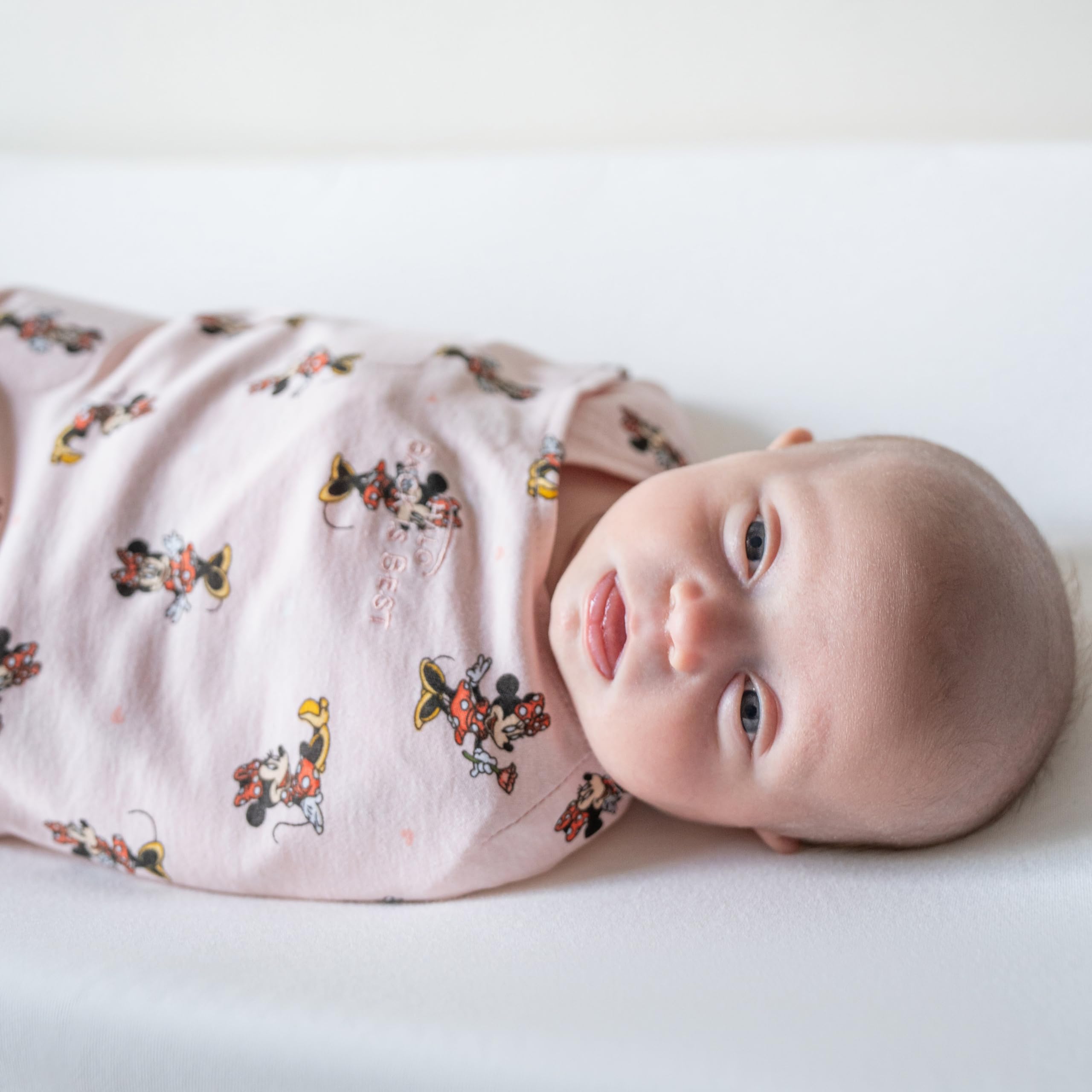 HALO Minnie Fun newborn fit highlights snug arm openings and safe sleep design.