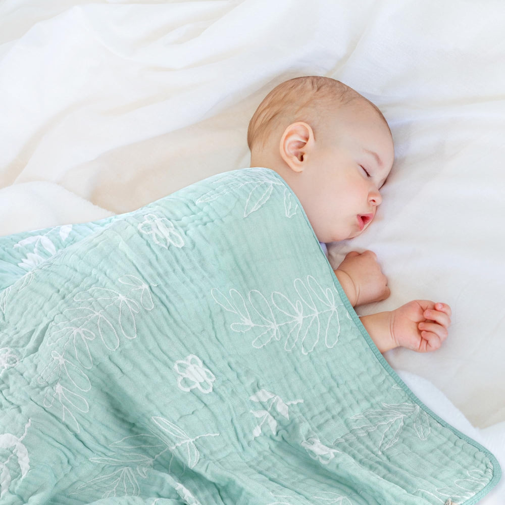 HardNok Leaf Floral Blanket wrapped baby demonstrates snug swaddle use for newborns.