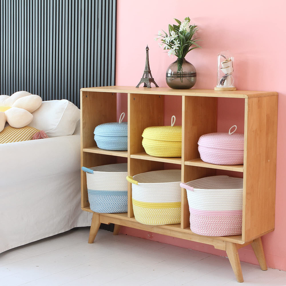 Hinwo nursery scene shows off-white and yellow basket organizing toys and clothes.