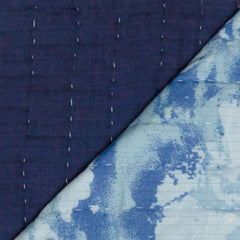 HonestBaby quilted blanket draped over a chair in a chic nursery.