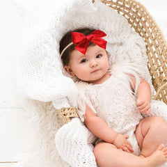 Hoyuwak baby bows on newborn girl during Christmas photo shoot.