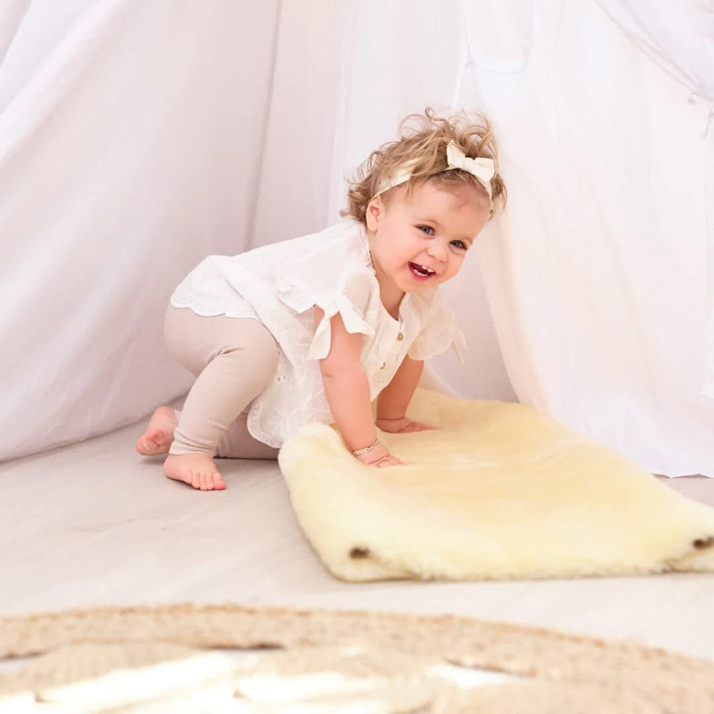 HUAHOO Premium Baby Sheepskin Rug champagne color on crib edge with breathable comfort