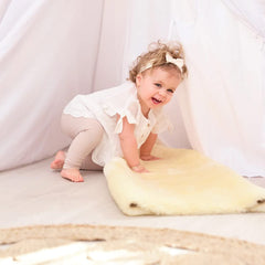 HUAHOO Premium Baby Sheepskin Rug champagne color on crib edge with breathable comfort