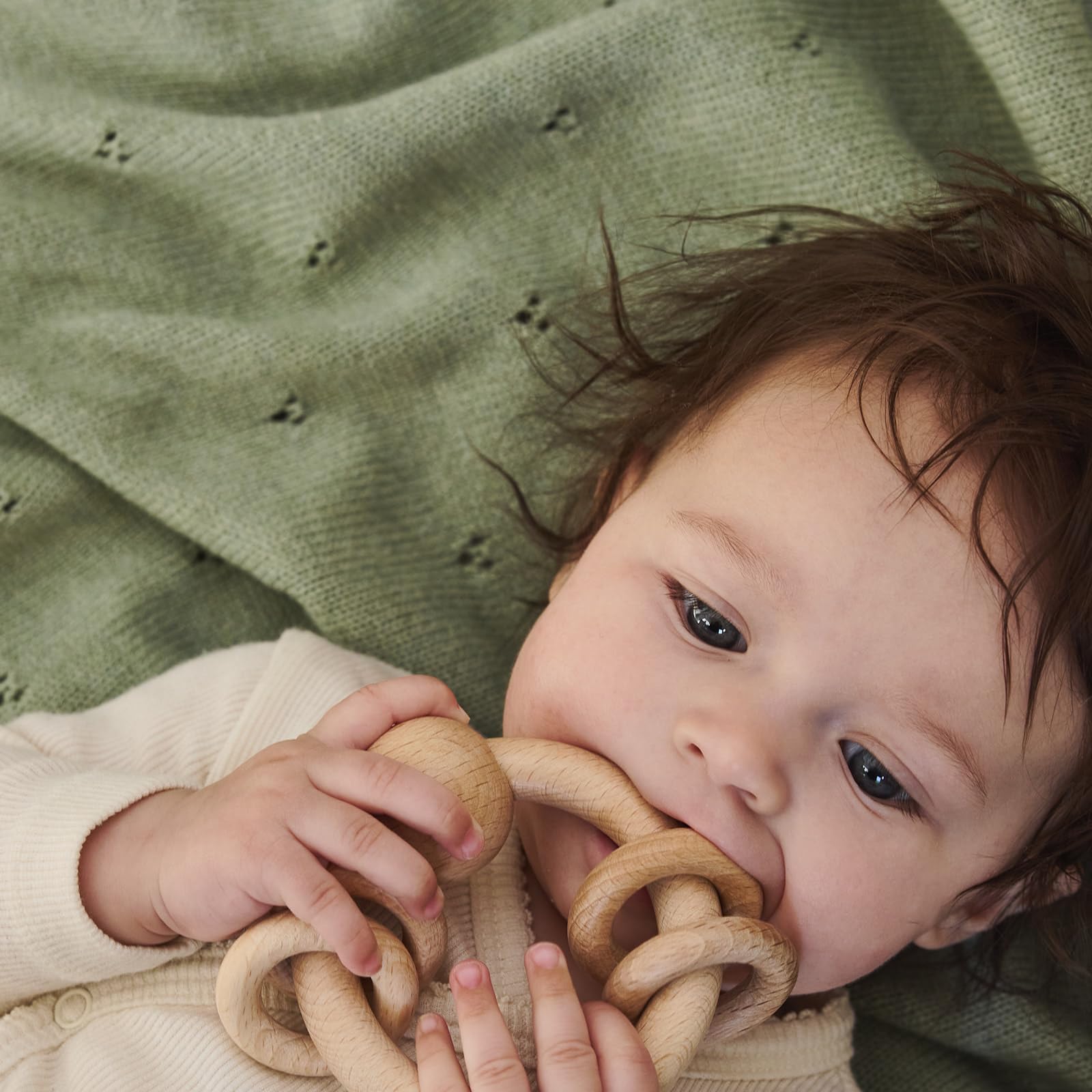 Huxie baby blanket in car seat usage providing cozy travel warmth.