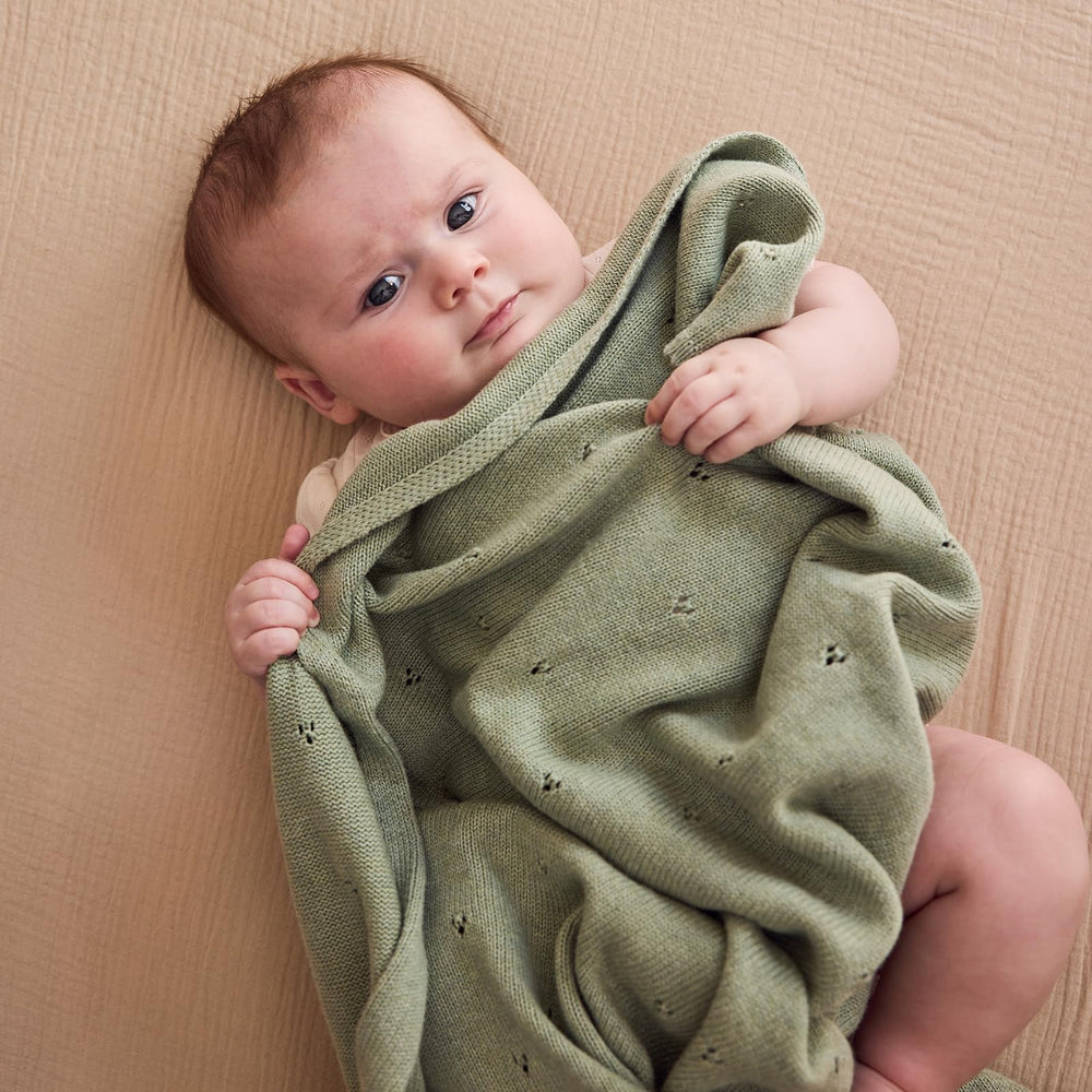 Huxie baby blanket in crib setup with breathable fabric for calm naps.