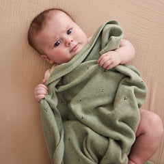 Huxie baby blanket in crib setup with breathable fabric for calm naps.