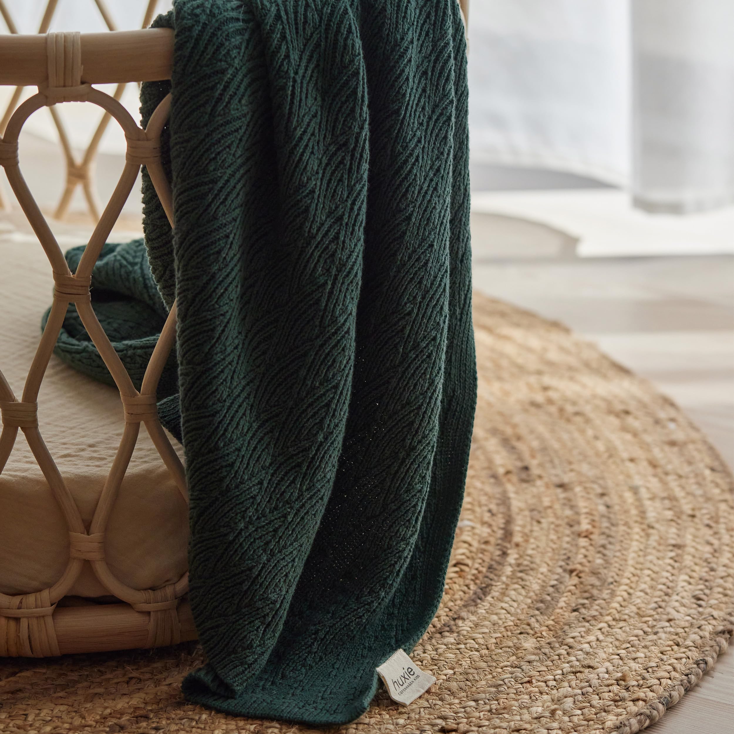 Huxie Knitted Baby Blanket beside crib highlights cozy nursery style
