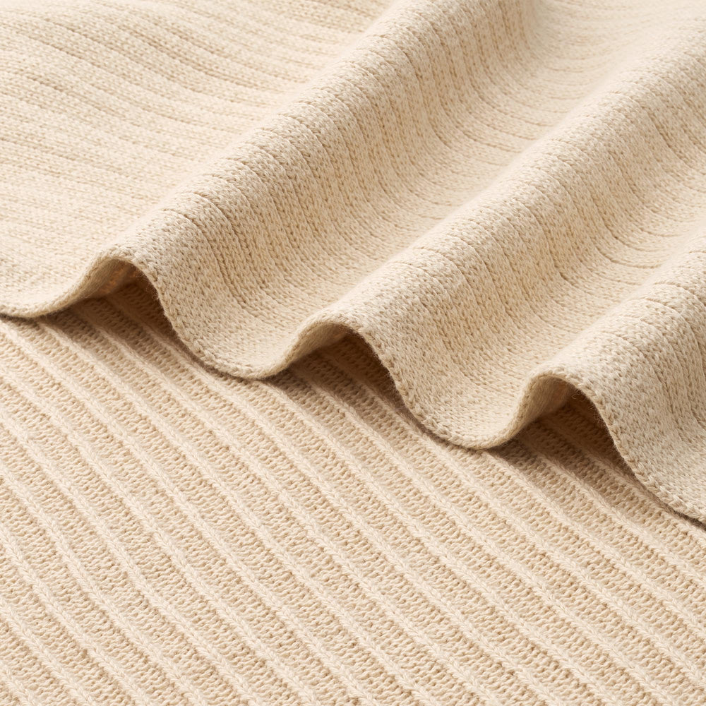 Huxie knitted baby blanket fog folded display highlights cozy warmth and modern design.