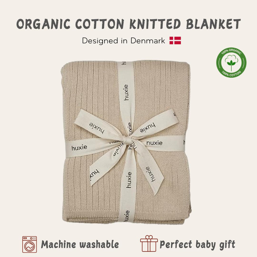 Huxie knitted baby blanket fog swaddle-use scene demonstrates versatile newborn comfort.