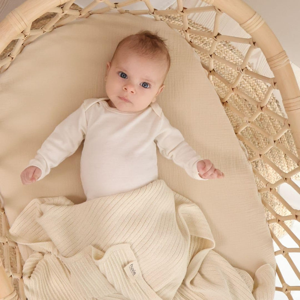 Huxie Knitted Baby Blanket in arms highlights cozy comfort during cuddle time