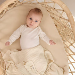 Huxie Knitted Baby Blanket in arms highlights cozy comfort during cuddle time