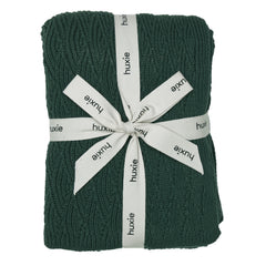 Huxie Knitted Baby Blanket texture close-up shows plush organic cotton softness